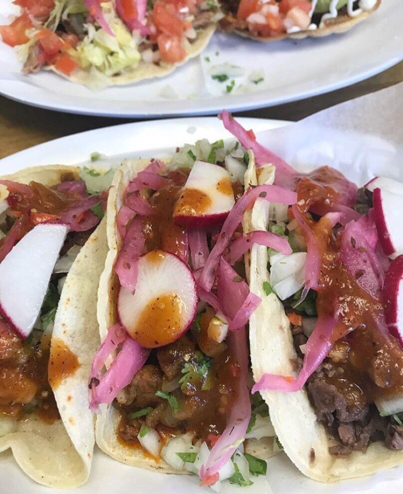 Tacos garnished with radish and pickled onion