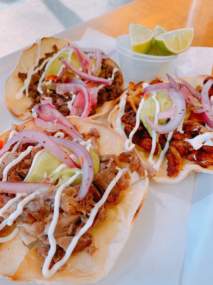 Carnitas vampiros with diced onion and lime wedges